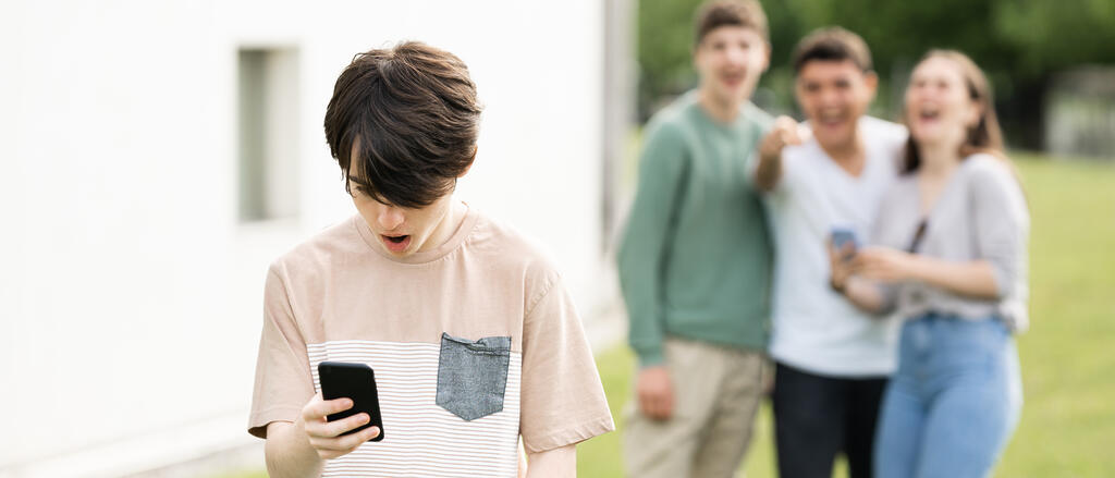 Ein Junge erlebt Cybermobbing auf seinem Smartphone.