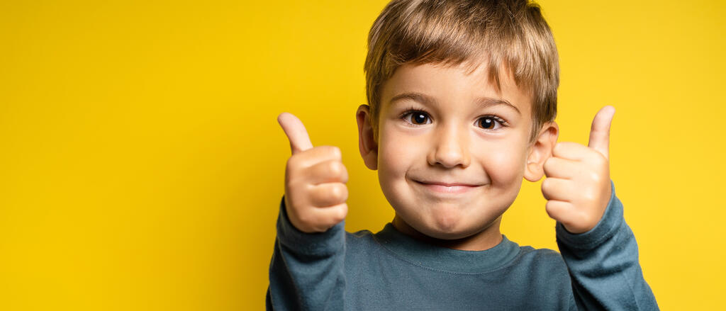 Junge zeigt zwei Daumen hoch