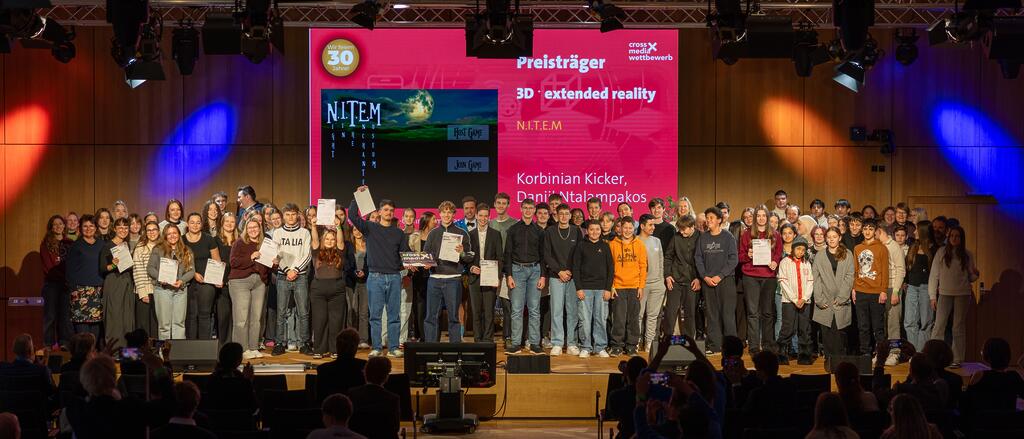 Jugendliche stehen in der Gruppe, halten die Auszeichnung zum crossmedia-Wettbewerb in den Händen. 