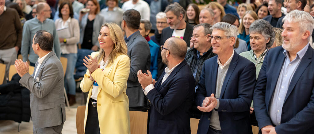 Kultusministerin Anna Stolz (mittig), klatschend, im Publikum