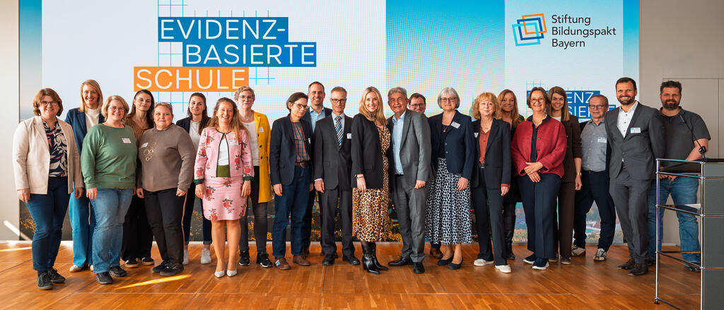 Kultusministerin Anna Stolz und Bertram Brossardt (Mitte) mit den Vertreterinnen und Vertretern der am Schulversuch teilnehmenden Schulen