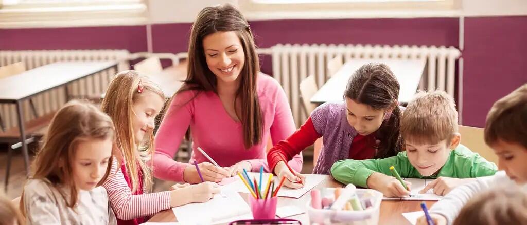 Lehrerin mit Kindern beim Malen